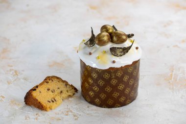 Beyaz kremalı Paskalya pastası ve altın çikolatalı yumurta ve yapraklarla süslenmiş.