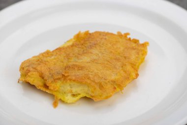 Bir dilim domates ve bir parça erimiş peynirli kızarmış patatesli krep..