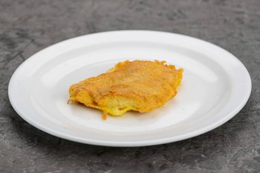 Bir dilim domates ve bir parça erimiş peynirli kızarmış patatesli krep..