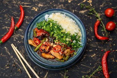 Tavuklu, sebzeli, biberli ve pirinçli kızarmış bir tabak..