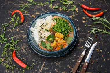 Lezzetli bir kase körili tavuk, pilav, havuç ve taze otlar..