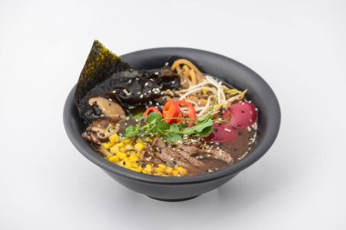 Etli, mısırlı, yumurtalı, mantarlı ve diğer sebzeli bir kase ramen..