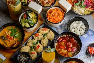 Bir masa dolusu Asya yemekleri, kokteyller ve gazete kaplamalı atıştırmalıklarla dolu..