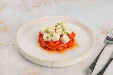 Kızarmış kırmızı biberli gurme aperatifi ve taze mikro-yeşillikli küp beyaz peynir..