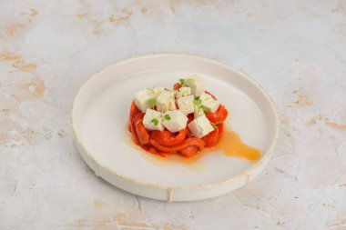 Kızarmış kırmızı biberli gurme aperatifi ve taze mikro-yeşillikli küp beyaz peynir..