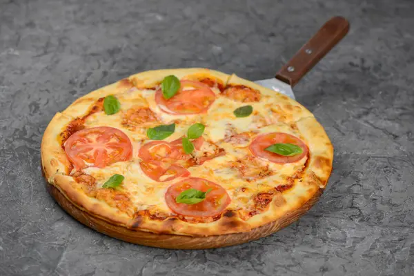 Tahta tahtada servis edilen domates ve fesleğenli taze margherita pizzası..