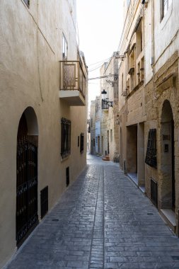 Typical narrow street with an ancient stone buildings in Mdina, Malta island.