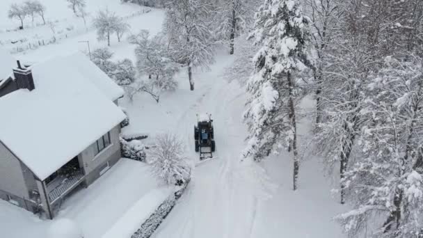青いトラクターは庭から雪をきれいにする — ストック動画