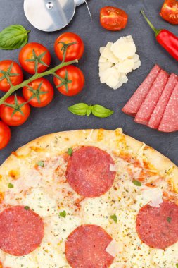 Pizza salami from above baking ingredients close up portrait format on a slate
