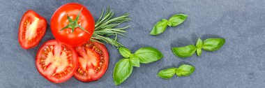 Tomatoes tomatos vegetables with basil from above banner slate top view