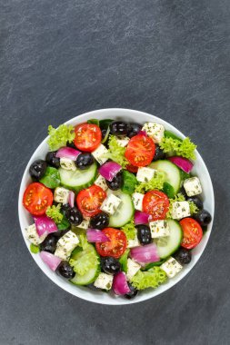 Taze domates zeytinli Yunan salatası ve feta peyniri. Telif alanı fotokopi alanı olan üst portre formatından sağlıklı yiyecekler.