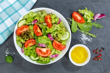 Karışık salata ve taze domates. Sağlıklı besleniyor. Yukardan yemek yiyor.