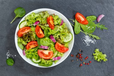Karışık salata ve taze domates. Sağlıklı besleniyor. Yukardan yemek yiyor.