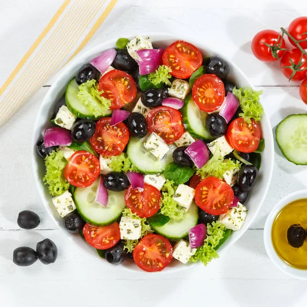 新鮮なトマトのオリーブとフェタチーズとギリシャのサラダ木製の板の正方形の上から健康的な食事を食べる食べる — ストック写真