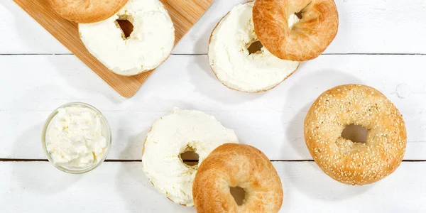 木の板のパノラマの上から朝食のための新鮮なクリームチーズとベーグルサンドイッチ — ストック写真