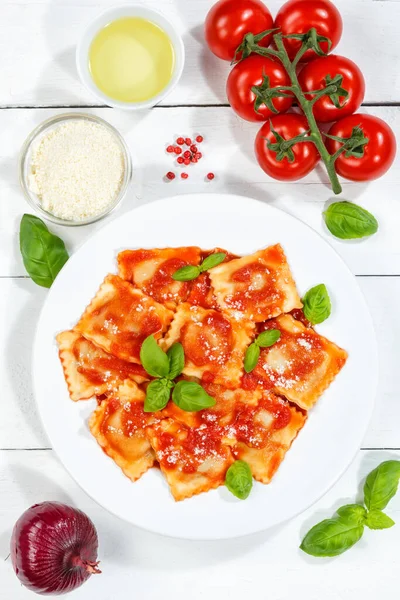 イタリアのラビオリパスタ料理ランチにトマトソーストップビューの皿と木の板の肖像画形式で食べる — ストック写真