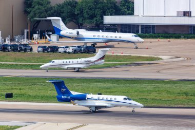 Dallas, ABD - 7 Mayıs 2023: Embraer Fenomen 300 ve Gulfstream G550 özel jet uçakları Dallas Love Field Airport 'ta (DAL).
