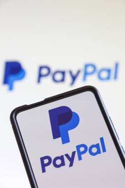 Stuttgart, Almanya - 20 Temmuz 2023: Stuttgart, Almanya 'daki bir cep telefonu ve bilgisayar ekranında online ödeme şirketinin PayPal logosu.