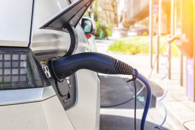 Şarj istasyonunda yeşil enerjili elektrikli bir aracın aküsünü şarj etmek.