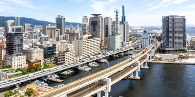 Japonya 'da liman ve yükseltilmiş karayolu köprüsü panoraması ile yukarıdan Kobe silueti