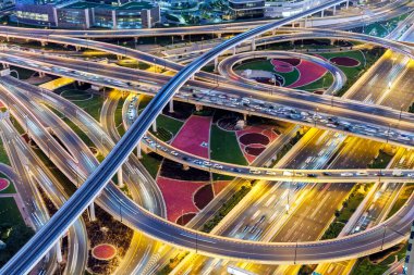 Dubai crossroads of Sheikh Zayed Road highway interchange traffic near Burj Khalifa with metro at twilight clipart