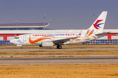 Beijing, China - March 31, 2024: China Eastern Boeing 737-700 airplane with Yunnan Peacock special livery at Beijing Daxing Airport (PKX) in China. clipart