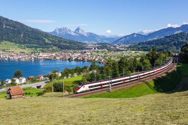 Yolcu treni tipi Stadler Giruno Schweizerische Bundesbahnen gülüşü SBB Grosser Mythen dağında İsviçre 'nin Arth şehrindeki Zug Gölü' nde