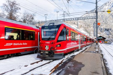 Filisur, İsviçre - 10 Ocak 2024: Rhaetian Demiryolu yolcu trenleri Stadler Demiryolu üzerinden İsviçre 'nin Filisur kentindeki tren istasyonunda.