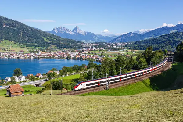 Yolcu treni tipi Stadler Giruno Schweizerische Bundesbahnen gülüşü SBB Grosser Mythen dağında İsviçre 'nin Arth şehrindeki Zug Gölü' nde