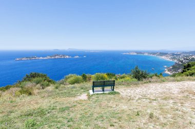 View from a bench on Arillas Bay with turquoise sea vacation on Corfu island in Greece clipart