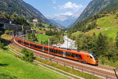 Wassen, İsviçre - 28 Ağustos 2024: İsviçre 'nin Wassen kentindeki Gotthard Alplerinde Suedostbahn' lı Stadler Flirt tipi yolcu treni.