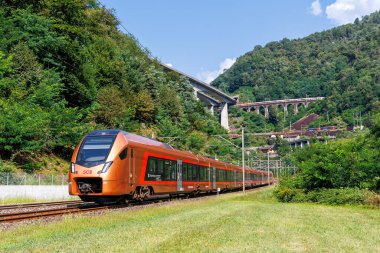 Giornico, Switzerland - August 28, 2024: Passenger train type Stadler Flirt of Suedostbahn on Gotthard railway in the Swiss Alps in Giornico, Switzerland. clipart