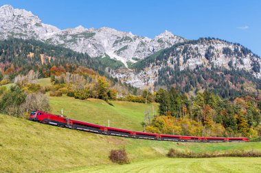 Braz, Austria - October 30, 2024: Railjet passenger train of Austrian Federal Railways on Arlberg railway line in autumn in the Austrian Alps in Braz, Austria. clipart