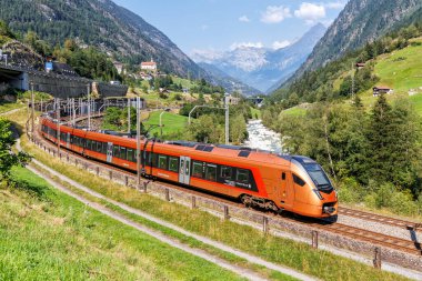 Wassen, İsviçre - 28 Ağustos 2024: İsviçre 'nin Wassen kentindeki Gotthard Alplerinde Suedostbahn' lı Stadler Flirt tipi yolcu treni.