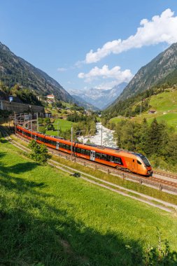 Wassen, Switzerland - August 28, 2024: Passenger train type Stadler Flirt of Suedostbahn on Gotthard railway in the Swiss Alps in Wassen, Switzerland. clipart