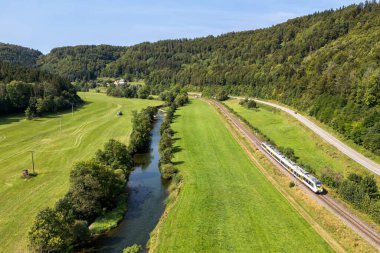 Sulz, Almanya - 23 Ağustos 2024: Almanya 'nın Sulz kentindeki Gaeubahn demiryolu hattında Deutsche Bahn DB Regio tipi Bombardıman Yeteneği 2 treninin hava görüntüsü.
