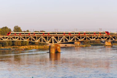 Varşova, Polonya - 19 Eylül 2024: SKM Warszawa tipi Newag Impuls treni Varşova, Polonya 'da Vistula nehri üzerinde köprü üzerinde.