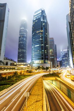 Hong Kong 'da gece trafiğinde caddeler ve gökdelenler Hong Kong, Çin' de portre formatında.