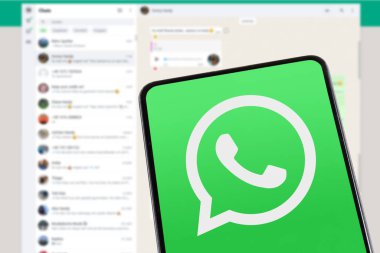 Stuttgart, Almanya - 8 Şubat 2025: WhatsApp logo kurye uygulaması Almanya 'nın Stuttgart kentindeki bir cep telefonu ve masaüstü bilgisayarına mesaj gönderiyor.