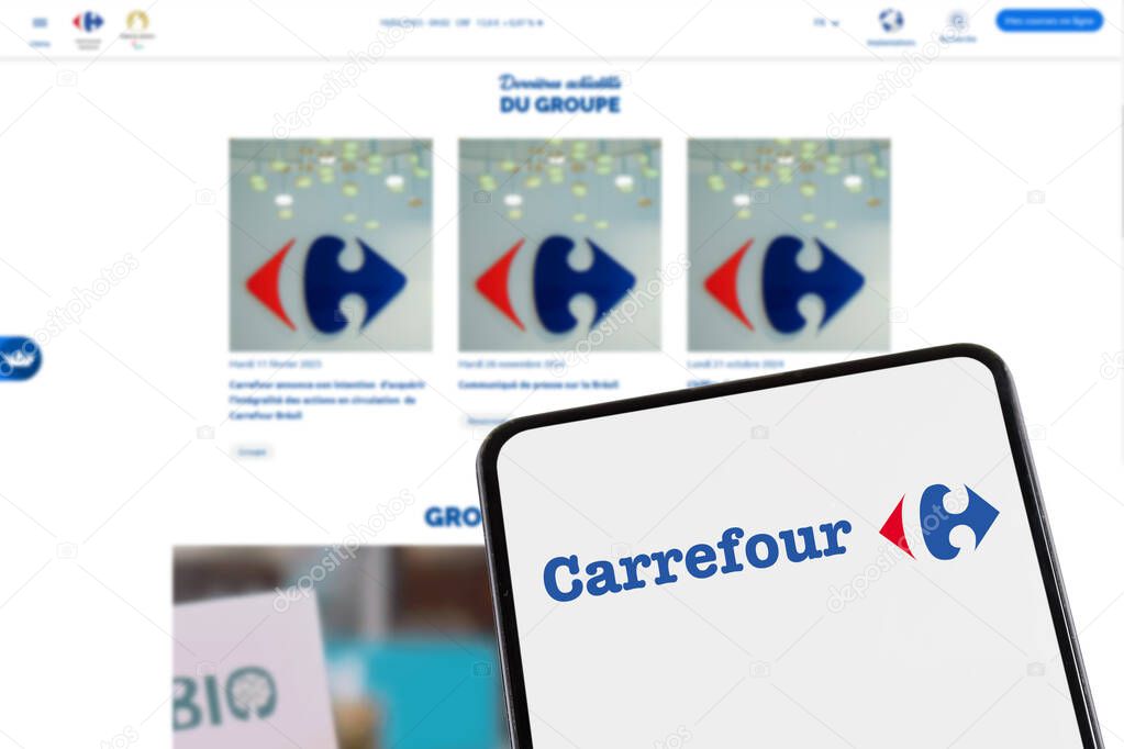 Stuttgart, Germany - February 8, 2025: Carrefour supermarket with online shop ecommerce logo on a mobile phone and website in Stuttgart, Germany.