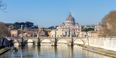 Roma, Vatikan 'daki Aziz Peter Bazilikası ile birlikte İtalya' daki Tiber nehrinin üzerindeki Ponte Sant 'Angelo köprüsüne yükseliyor.