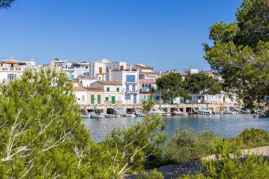 Mallorca adasındaki Portocolom balıkçı köyü. Tekneleri ve renkli evleri ile İspanya 'da deniz kenarında yaz tatili.