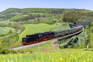 Blumberg, Deutschland - 2. Mai 2025: Dampfzug der Sauschwaenzlebahn Dampfbahn Eisenbahn Bahn Dampflok am Biesenbach-Viadukt, Blumberg, Deutschland.