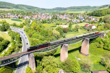 Ftzen, Almanya - 2 Mayıs 2025: Sauschwaenzlebahn buharlı tren lokomotif görüntüsü yukarıdan Ftzen, Almanya 'daki viyadük.