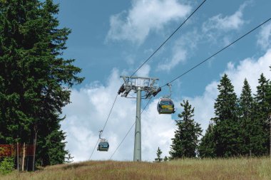 21 Temmuz 2025, Cerna Hora Janskie Lazne, Çek Cumhuriyeti. Cerna Hora Dağı 'ndaki Cableway Sistemi. Güneşli güzel bir yaz günü. Çayırdan görünen kabin asansörü.