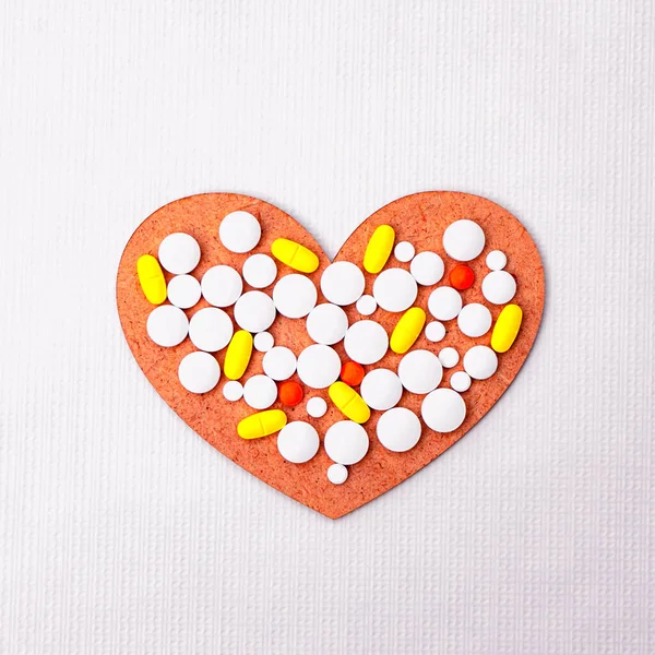 白い背景に心臓に位置する多色の錠剤 — ストック写真