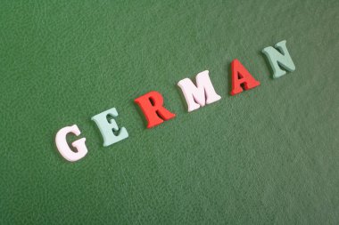 Almanca 'da yeşil arkaplan kelimesi alfabe bloklu tahta harflerden oluşmuştur. Reklam metinleri için kopyalama alanı. İngilizce öğrenme kavramı