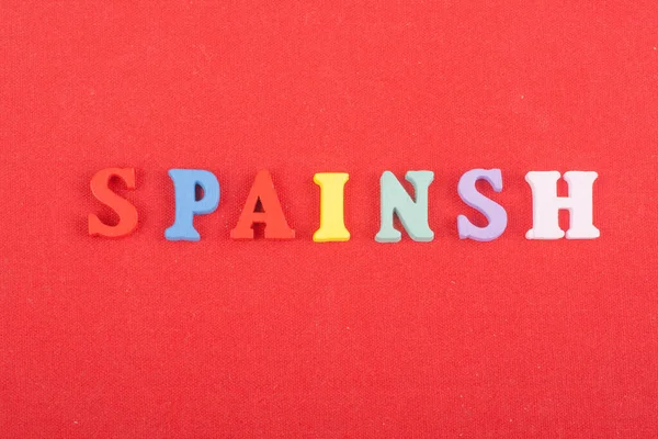 カラフルなAbcアルファベットブロック木製の文字から成る赤の背景にスペイン語の単語 広告テキストのためのコピースペース 英語の概念を学ぶ — ストック写真