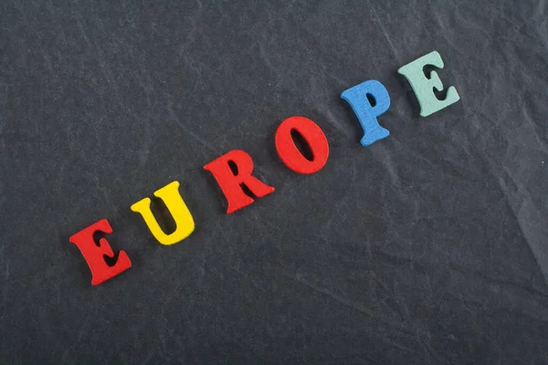 EUROPE word on black board background composed from colorful abc alphabet block wooden letters, copy space for ad text. Learning english concept