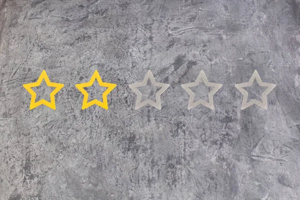 Gold, gray, silver five star shape on the gray concrete background. The best excellent business services rating customer experience concept. Concept image of setting a five star goal. Increase rating or ranking, evaluation and classification idea